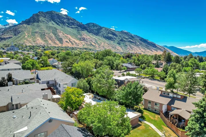 Expansive mountain backdrop with a residential area featuring mature trees and established homes