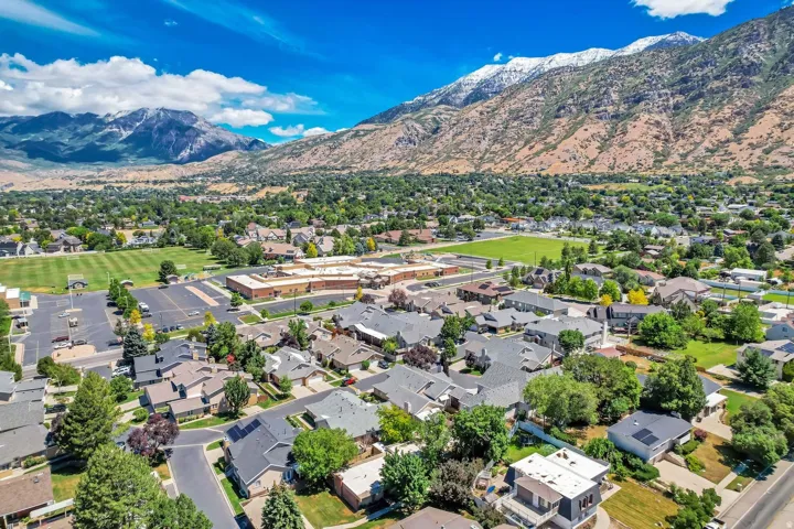 Expansive residential community with established homes, mature trees, and mountainous backdrops