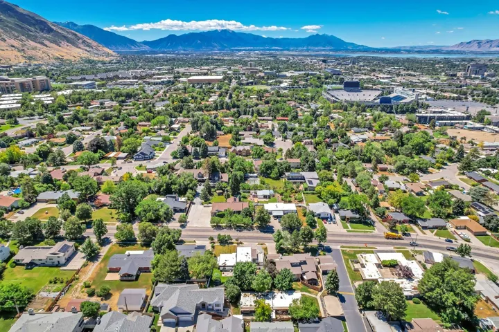 Aerial perspective highlighting a residential area with varied rooflines and extensive mature trees
