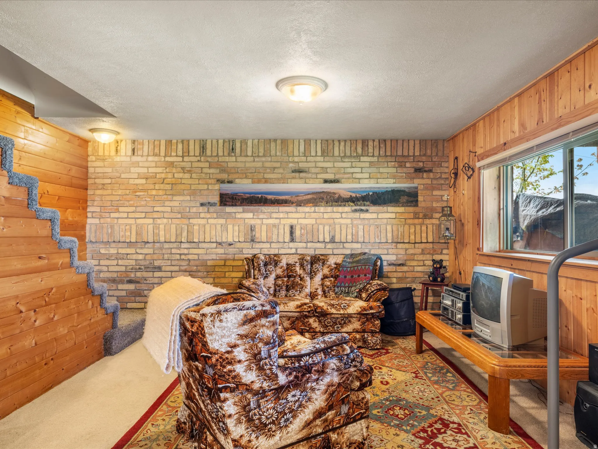 Recreation space featuring exposed brick and wood panel walls