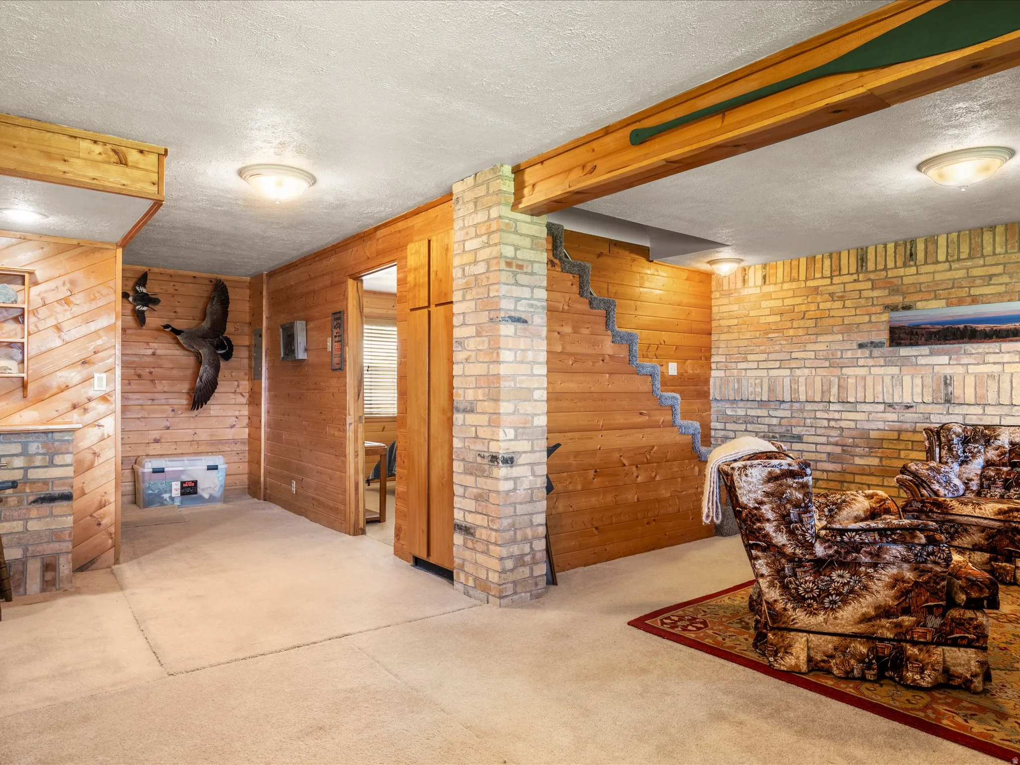Recreational space featuring extensive wood paneling and exposed brickwork
