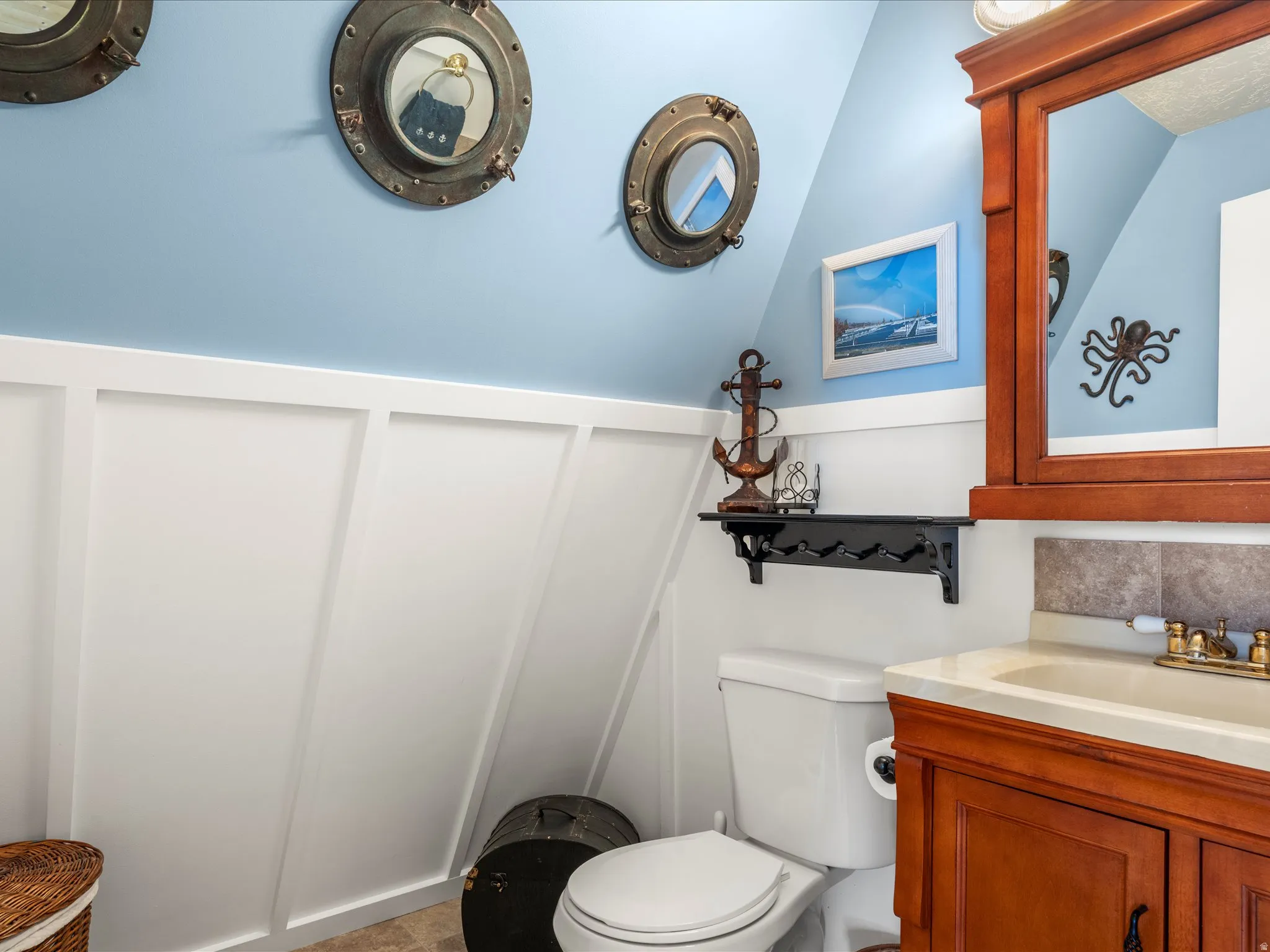 Bathroom vanity featuring a wood-finish cabinet, integrated sink, and brass-tone fixtures