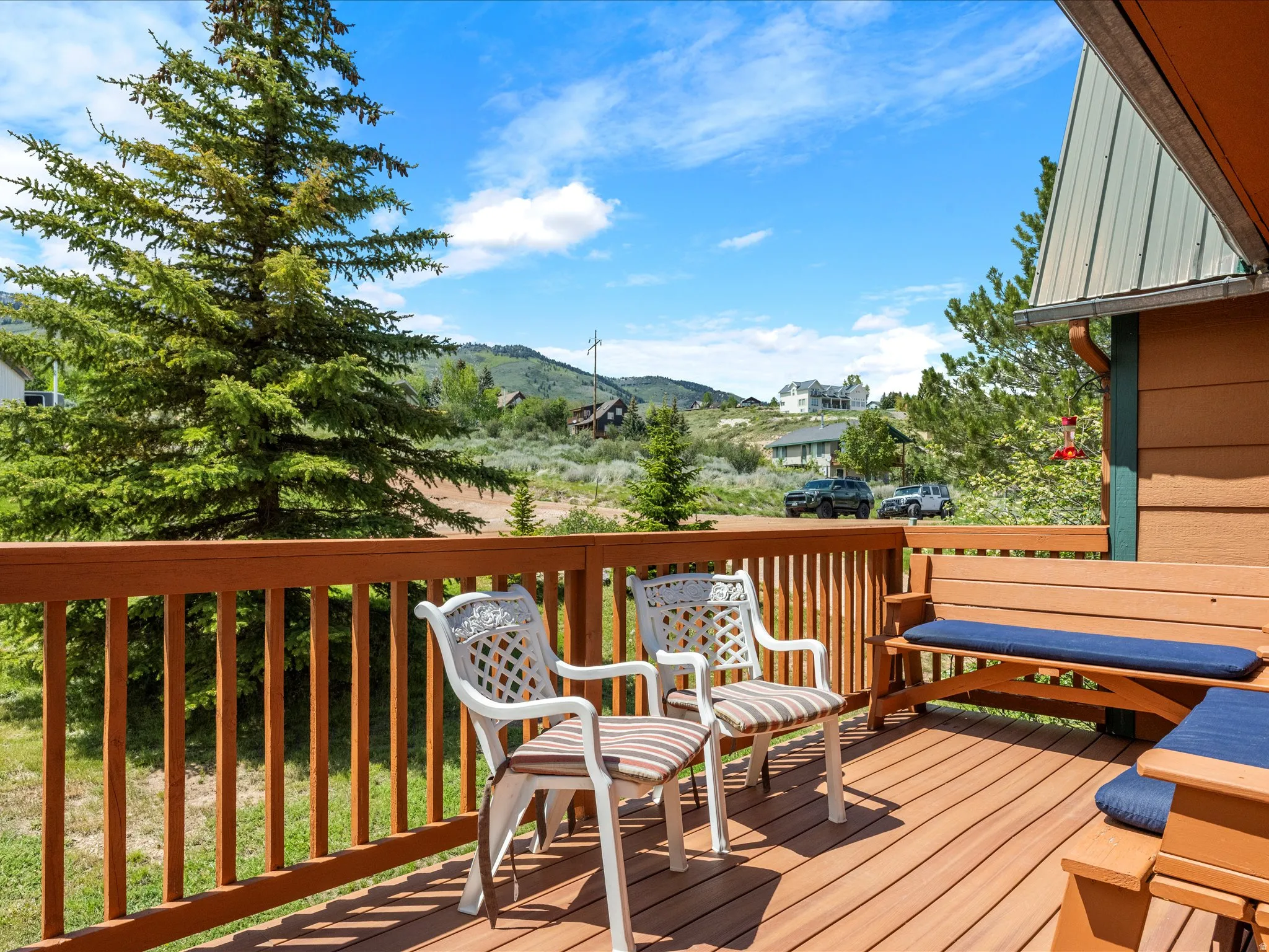 Expansive wood-finish deck with wooden railing and built-in bench seating