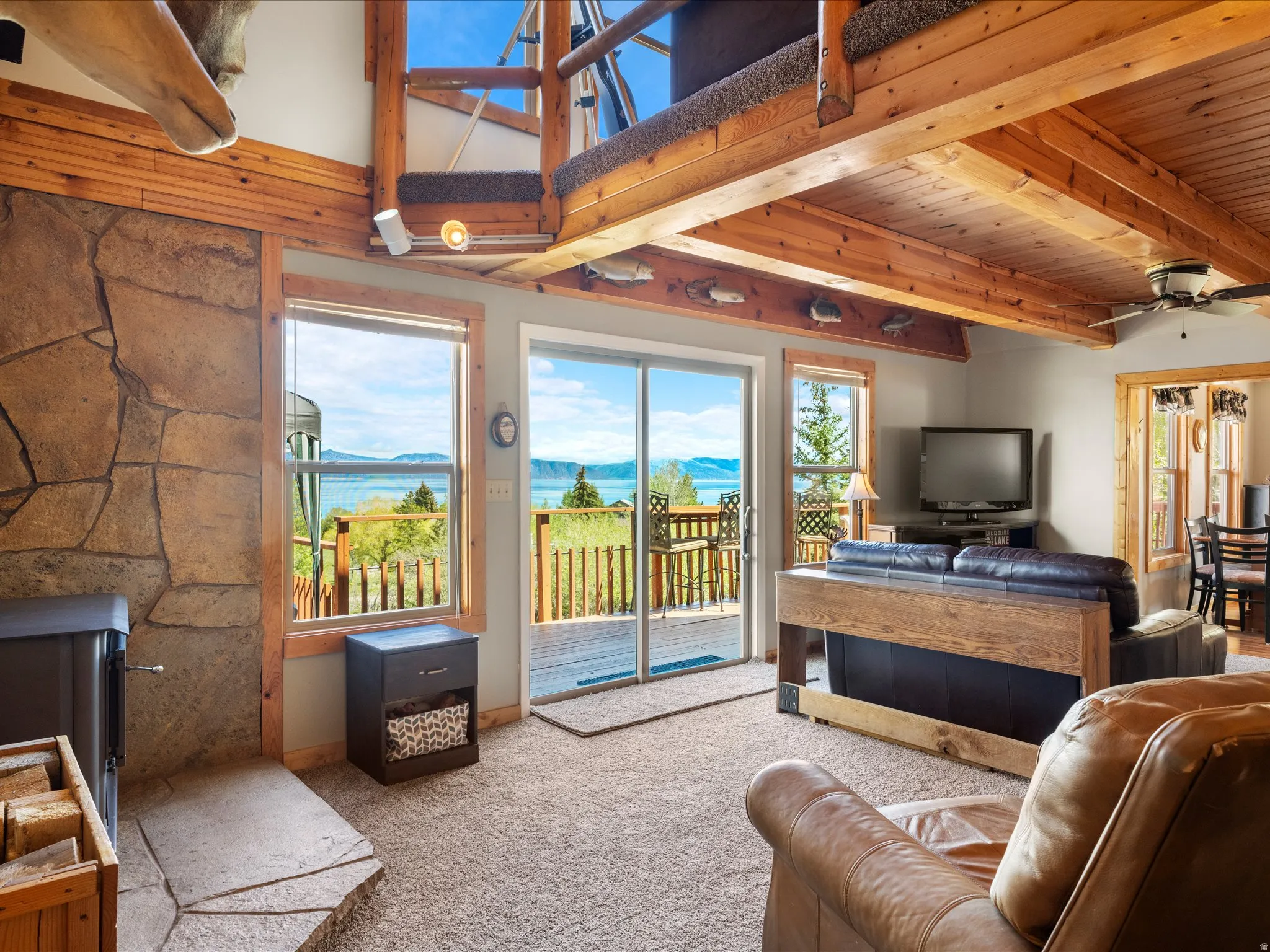 Living area featuring a stone-clad fireplace and wood-finish ceiling