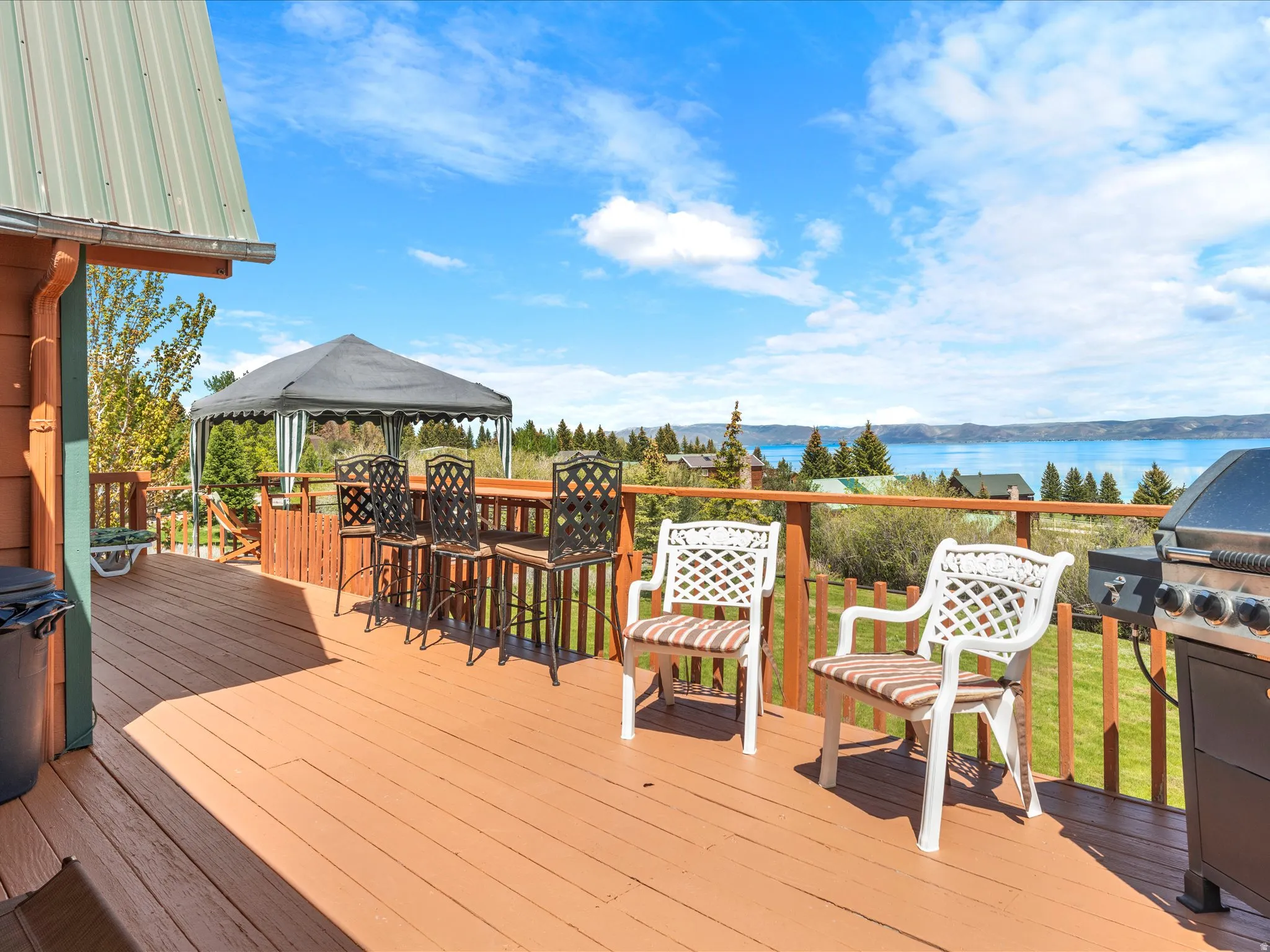 Expansive outdoor deck with a warm wood-finish surface, offering a broad water expanse backdrop