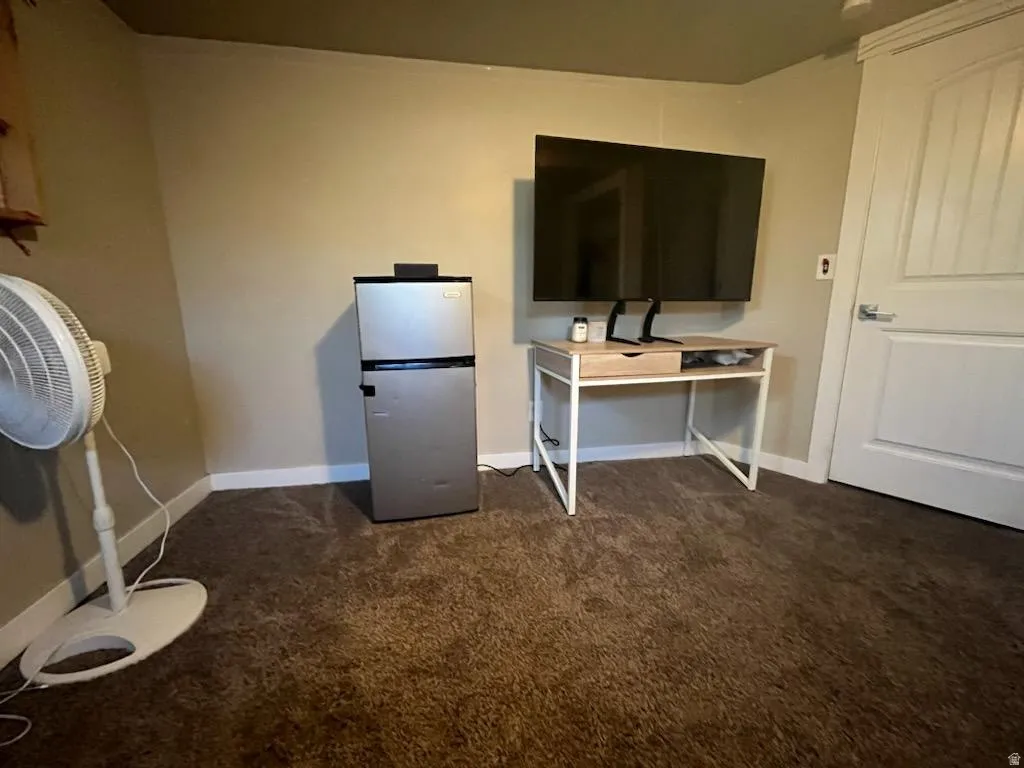 Carpeted room with neutral wall tones and white baseboards
