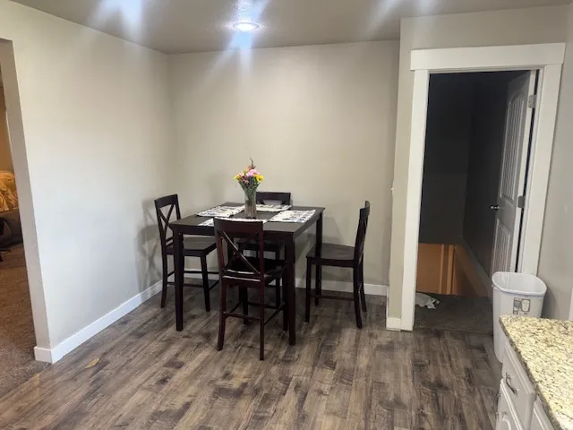 Open concept living area featuring wood-finish flooring, recessed lighting, and crisp white baseboards