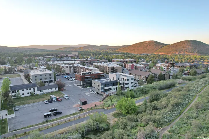 Expansive aerial perspective showcasing a townscape nestled against a backdrop of rolling hills