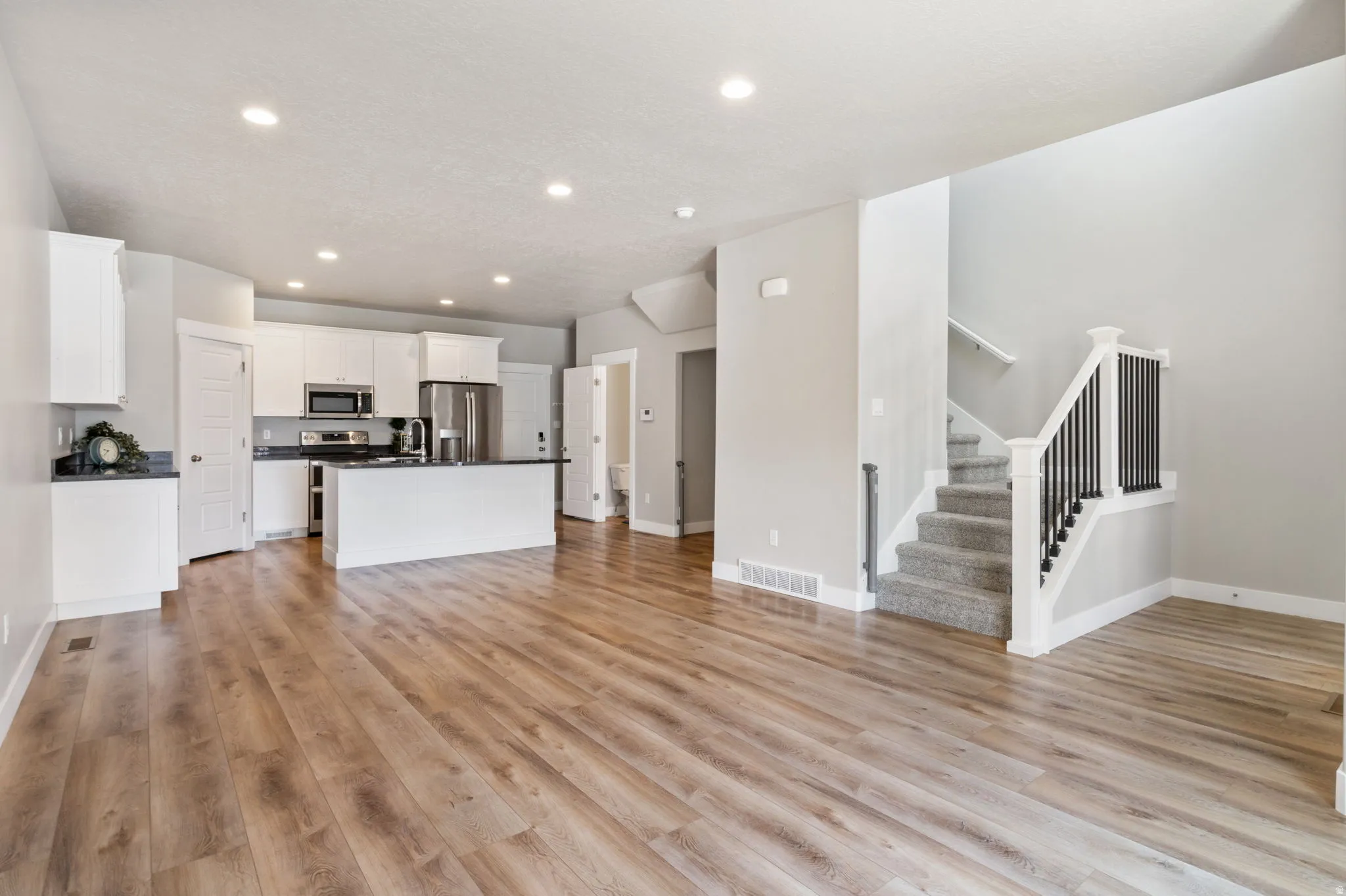 Open concept living space featuring wood-finish flooring throughout the main area