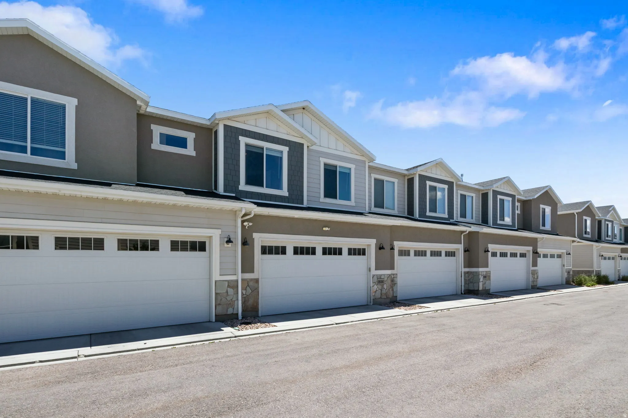 Contemporary townhome exteriors featuring two-car garages with window accents