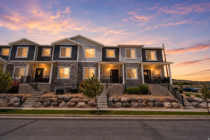 Townhome exterior featuring varied siding materials including stone veneer, horizontal siding, and shake accents
