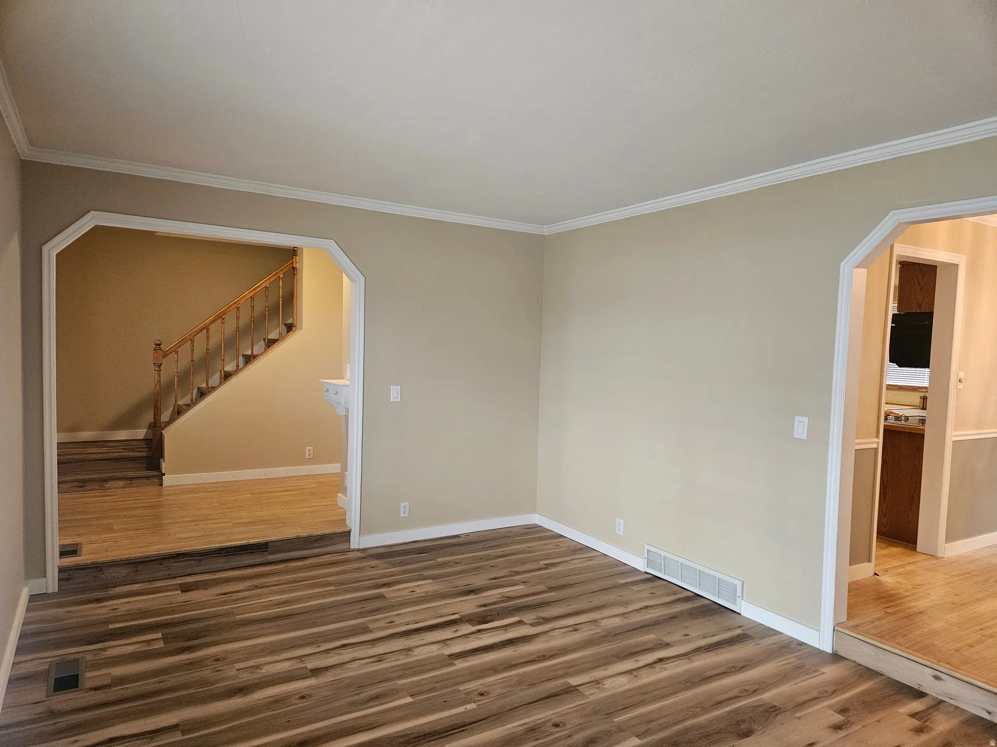 Spacious room featuring wood-finish flooring and neutral wall tones