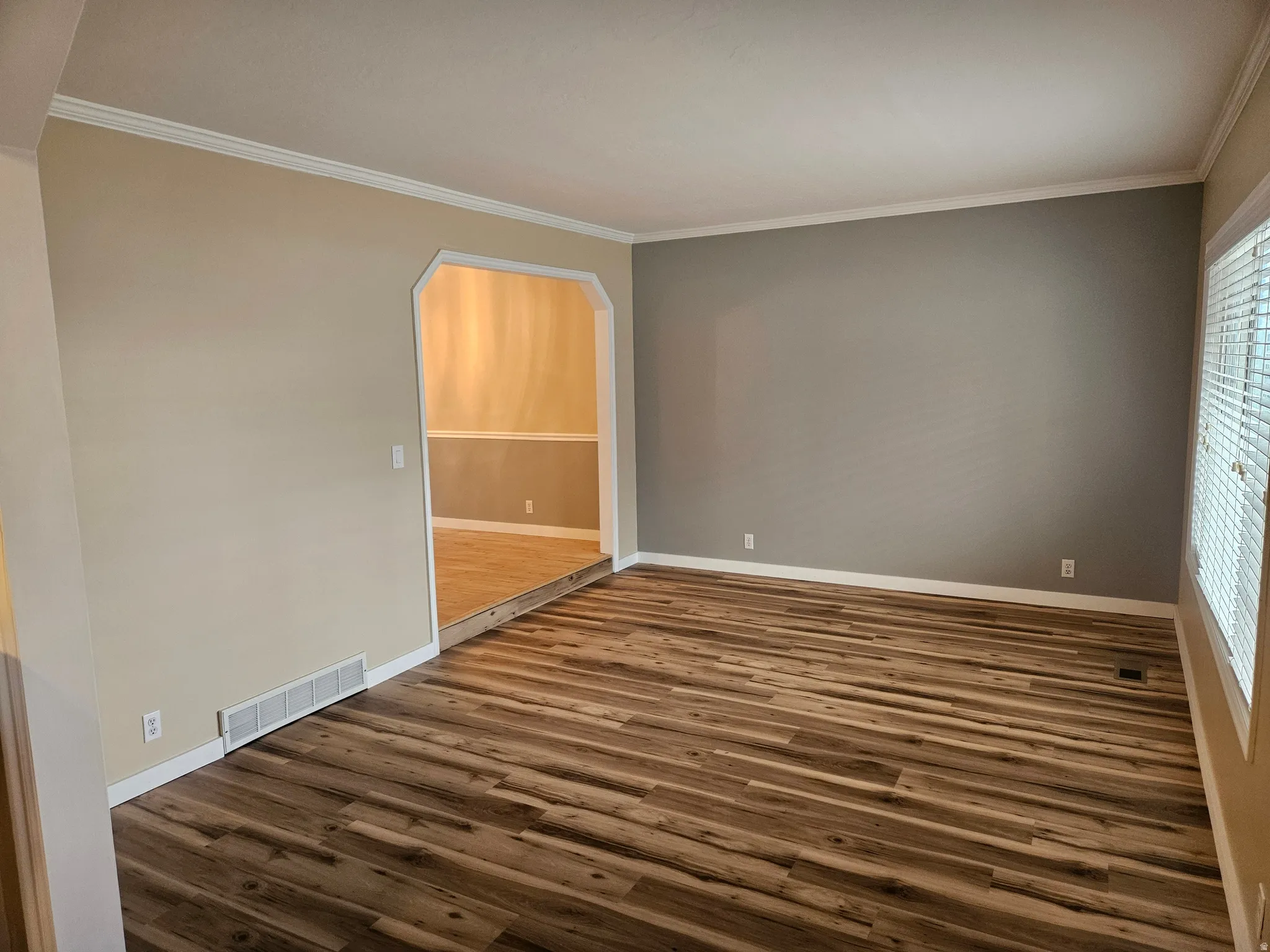 Spacious interior featuring wood-finish flooring, neutral paint tones, and white trim molding