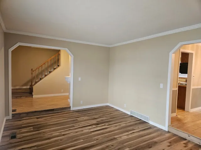 Spacious room featuring wood-finish flooring and neutral wall tones