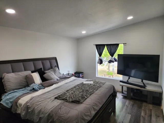 Spacious room featuring wood-finish flooring, recessed lighting, and a large window