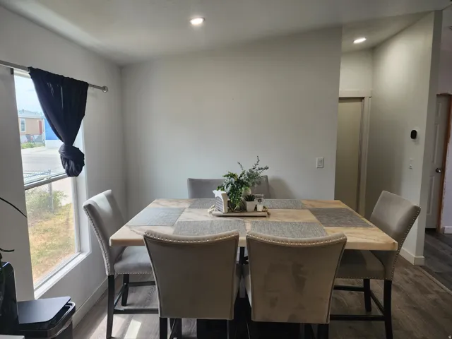 Dining area featuring light gray walls, recessed ceiling lighting, and wood-finish flooring