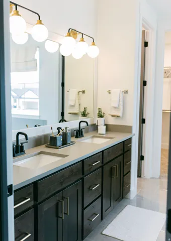Double vanity with dark wood-finish cabinetry, light-toned countertops, and dual undermount sinks