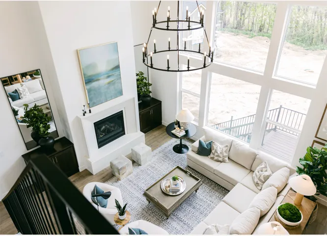 Two-story living area with a contemporary chandelier, a fireplace, and expansive windows
