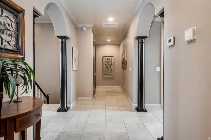 Hallway featuring arched entryways and decorative columns