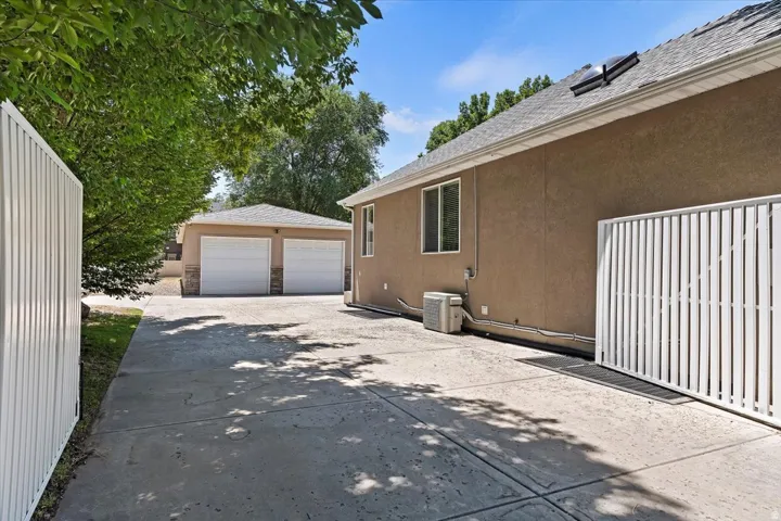 Paved driveway extending to a detached two-car garage with stone accents