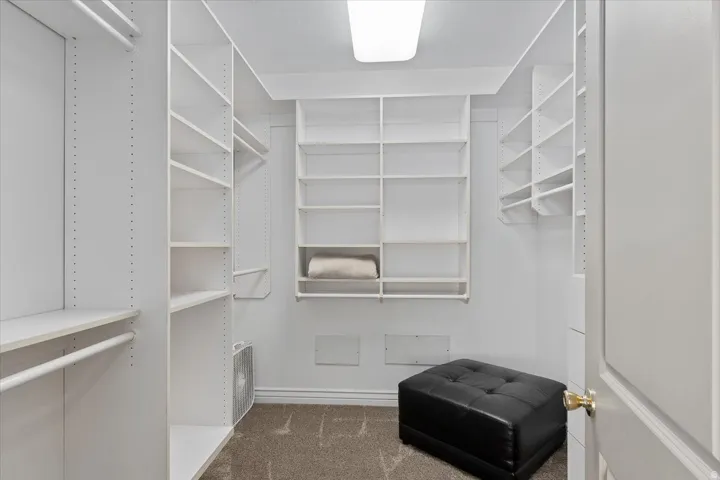 Walk-in closet featuring extensive built-in shelving, multiple hanging rods, and recessed ceiling lighting