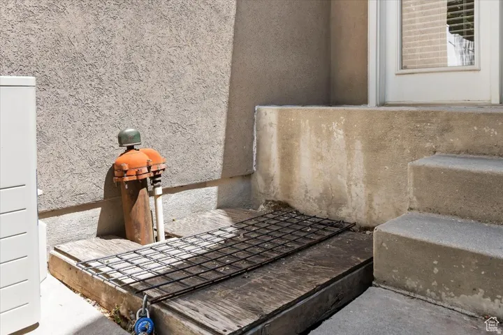 Exterior wall with stucco finish, a white door frame, and concrete steps