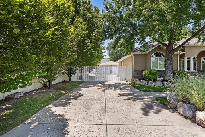Concrete driveway leading to a gated access point