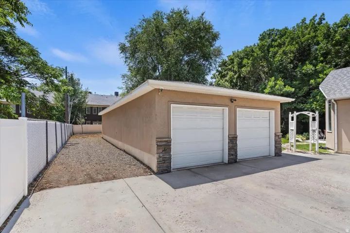 Two-car detached garage featuring stucco exterior and stacked stone accents