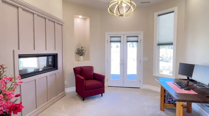 Room featuring a built-in fireplace with a linear firebox, a double French door, a tall window with cellular blinds, a lighted wall niche, and carpet flooring