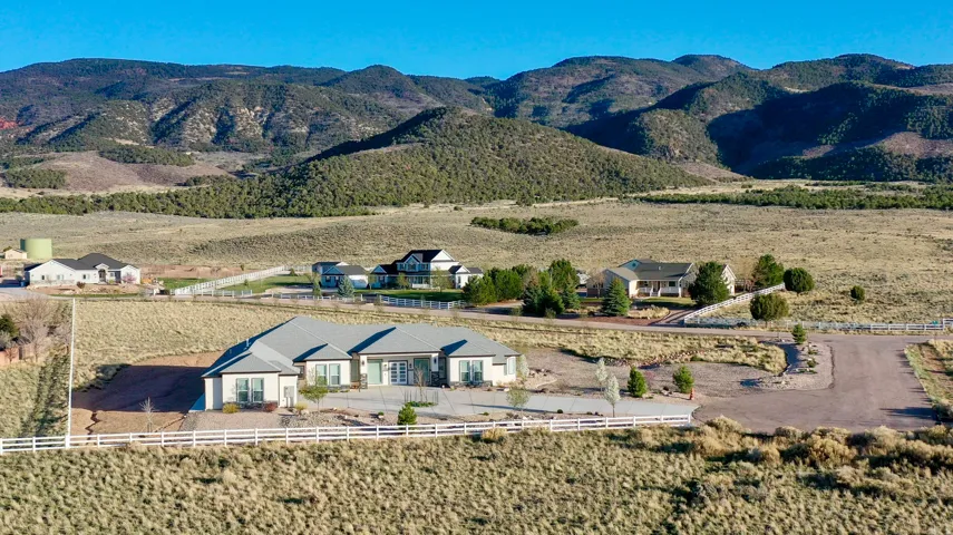 Ranch-style residence featuring a light-colored exterior with dark trim accents and a multi-pitch roof