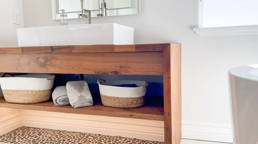 Floating wood vanity with a white vessel sink and polished chrome faucet