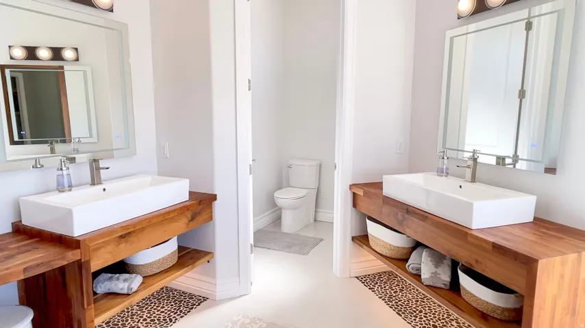 Dual vanity area featuring two vessel sinks, wood-finish countertops, and chrome fixtures