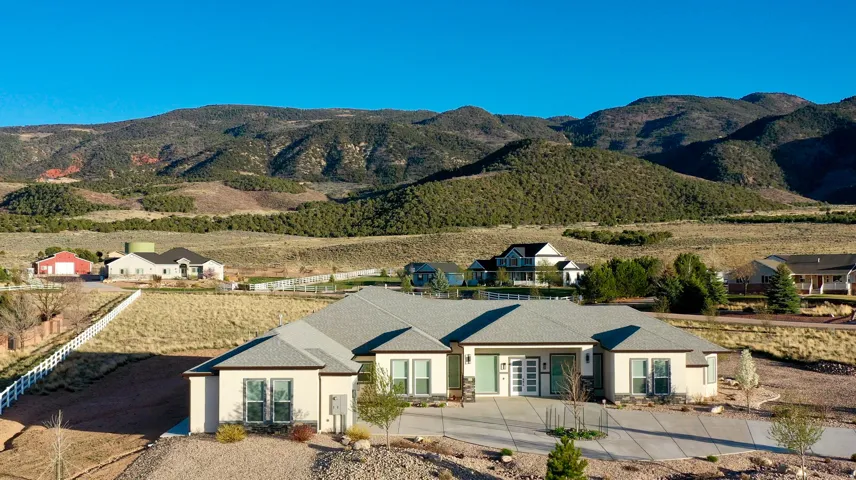 Contemporary ranch-style residence featuring a light-colored stucco exterior with dark trim accents