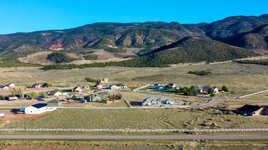 Expansive rural landscape featuring residential properties set against a mountainous backdrop