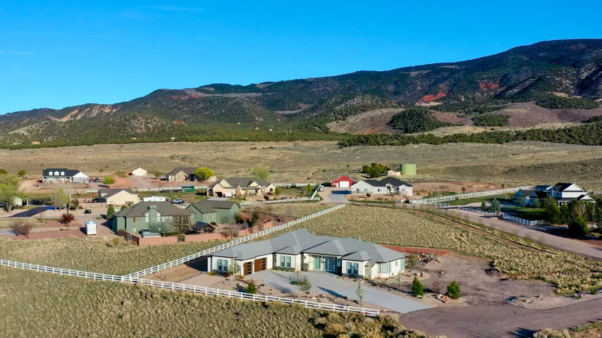 Sprawling property featuring a ranch-style residence with a light-colored exterior and a prominent mountain backdrop