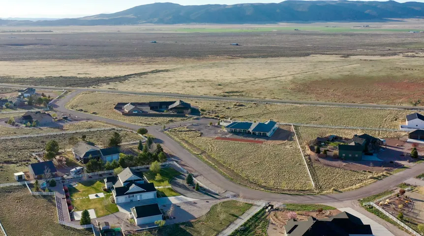 Expansive vacant lot with a distinct triangular shape, bordered by a paved road