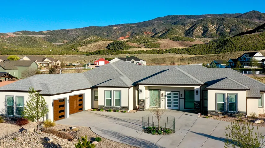 Contemporary stucco exterior with a gray shingle roof