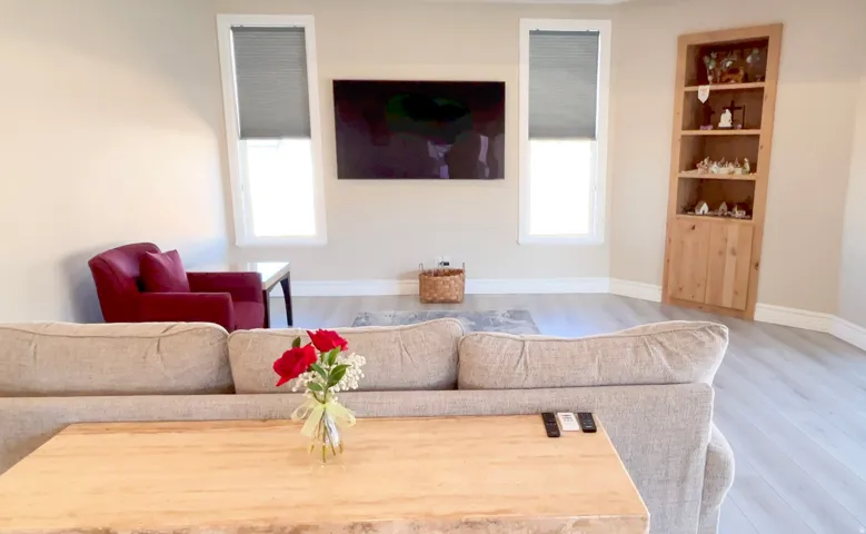 Living area featuring light wood-finish flooring, neutral wall tones, and white baseboards
