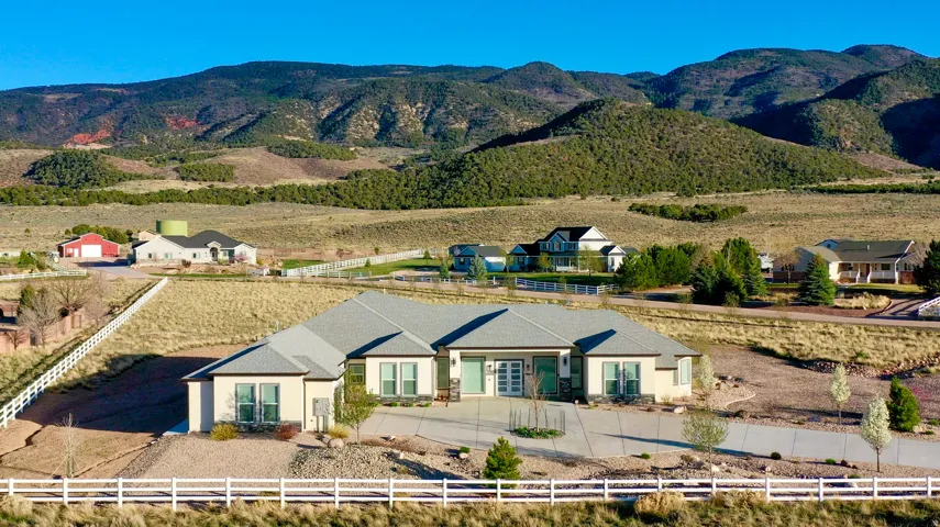 Contemporary ranch-style residence featuring a stucco exterior and a gray shingled roof
