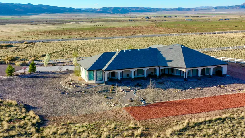 Expansive single-story ranch-style residence featuring a dark shingle roof and light-toned exterior