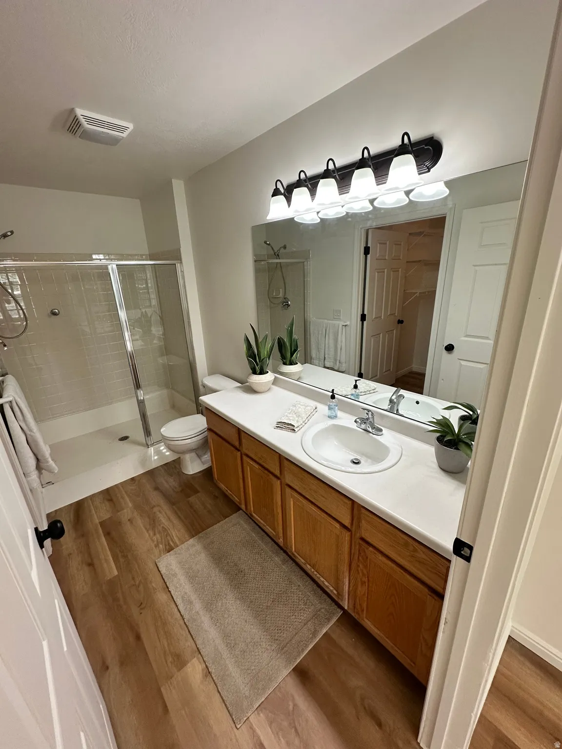 Bathroom vanity featuring a single sink, light-toned countertop, and wood-finish cabinetry