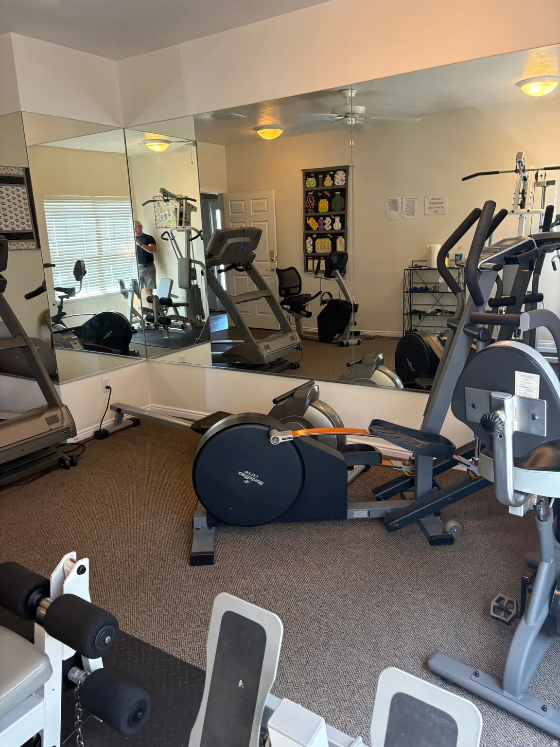 Clubhouse, Fitness center featuring full-wall mirrors and textured carpet flooring