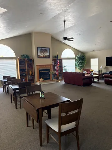 Clubhouse, Spacious gathering area featuring vaulted ceilings, a central fireplace, multiple arched windows, and recessed lighting