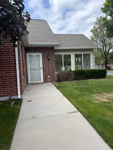 Brick exterior with a gabled roof and an enclosed sunroom