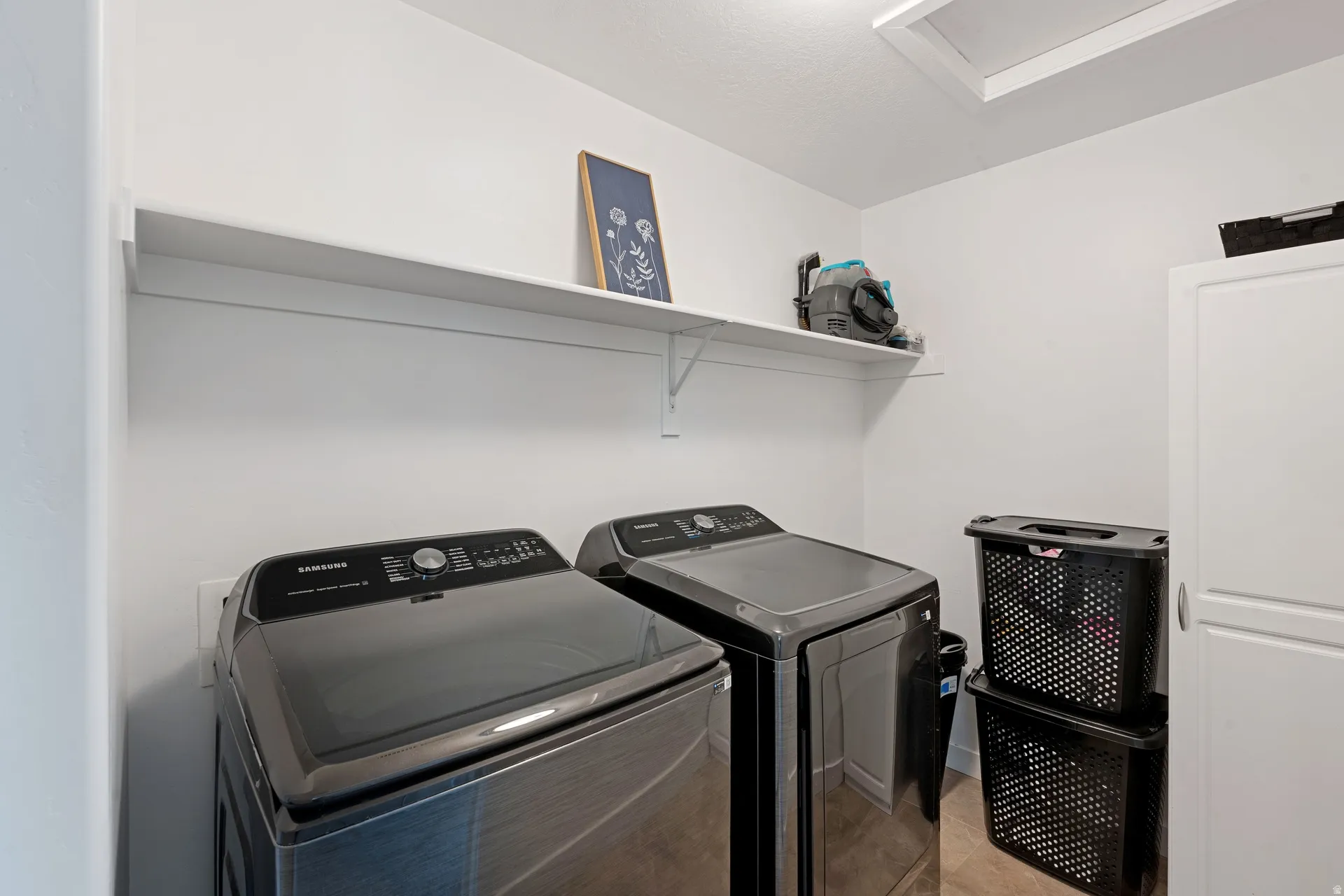 Dedicated laundry area featuring a built-in white shelf and light-toned flooring