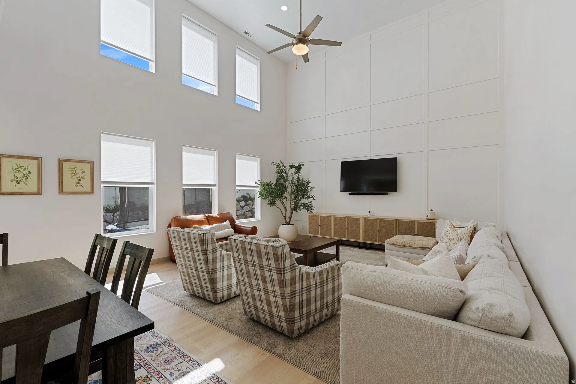 Two-story living area with high ceilings, upper and lower windows, and a ceiling fan