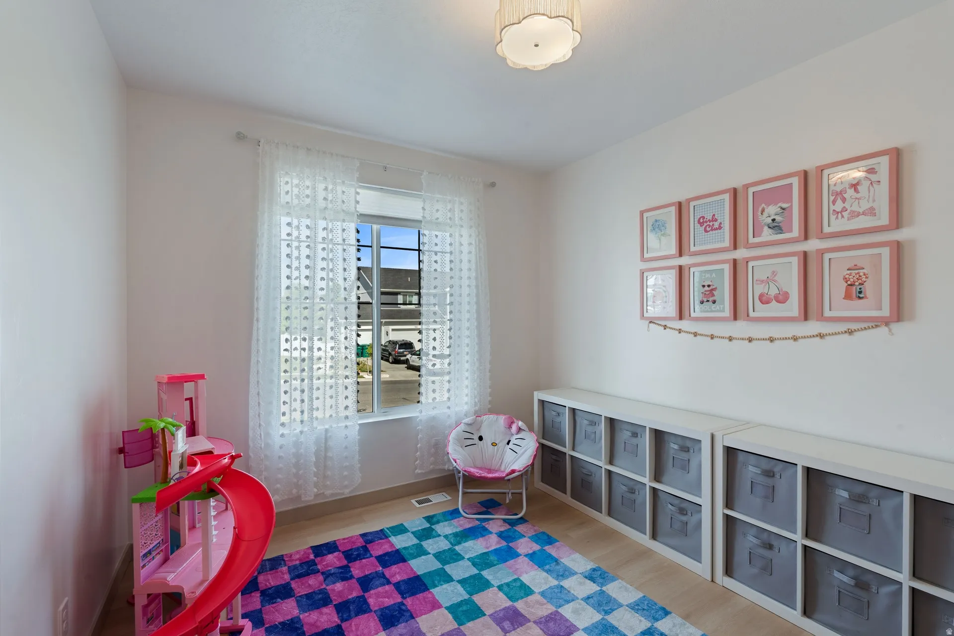 Bright room with a large window, light wood-finish flooring, and a flush-mount ceiling light fixture