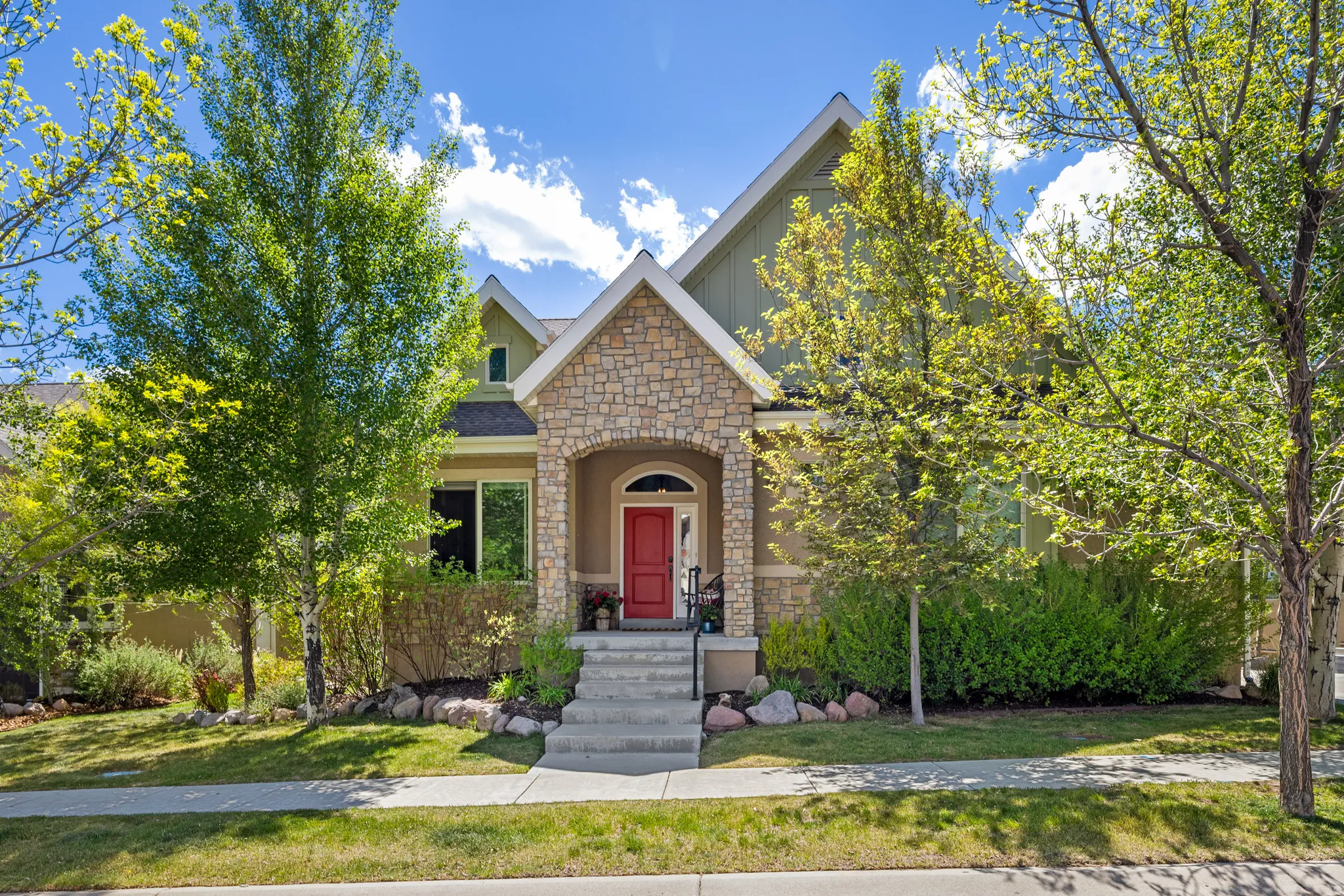 Traditional-style residence featuring a prominent stone facade and a vibrant red entry door