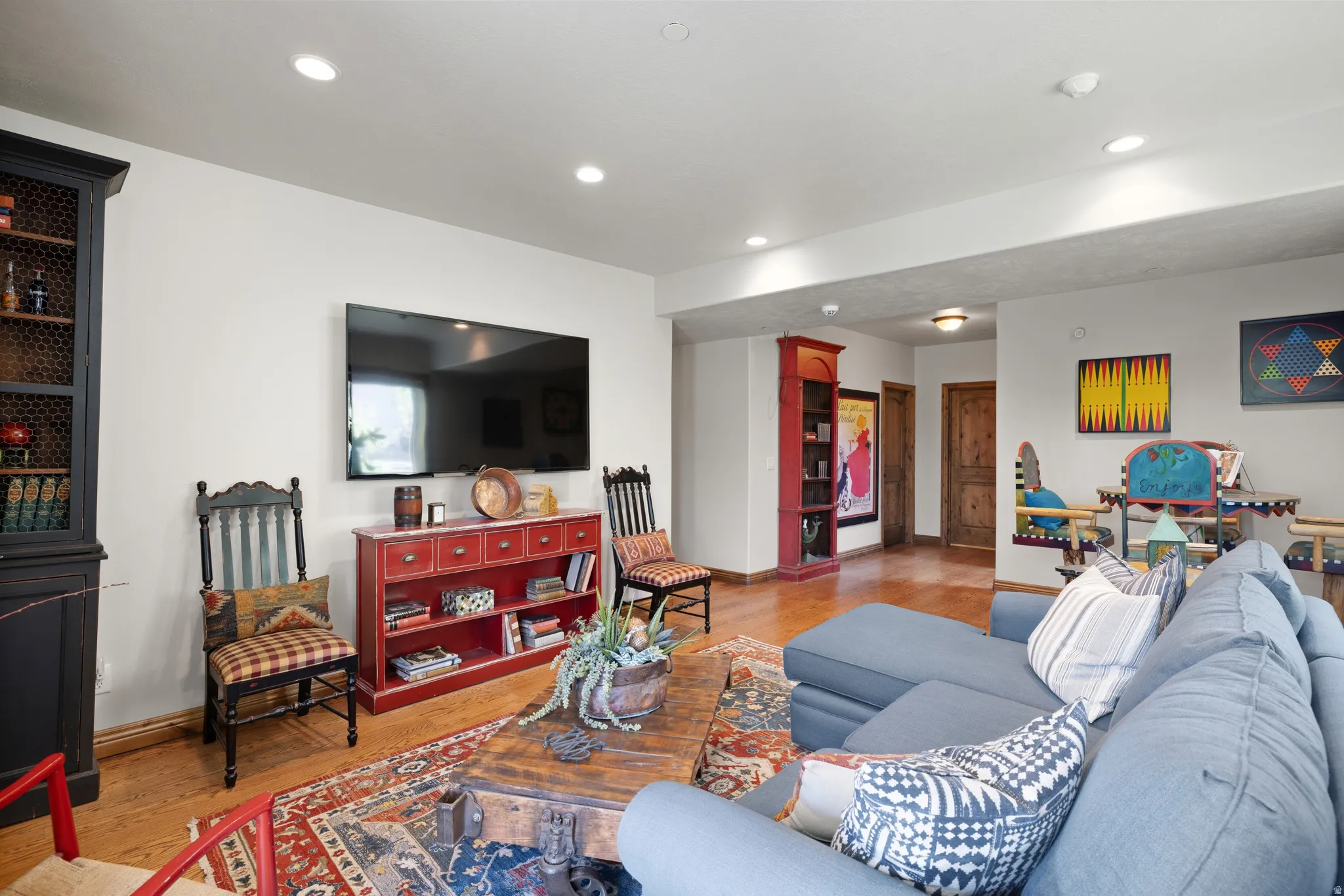 Spacious living area featuring wood-finish flooring, recessed lighting, and white walls