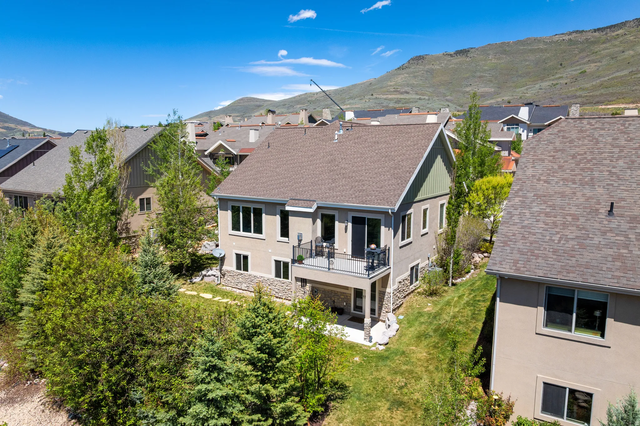 Multi-level residence featuring a stucco exterior and stone accents